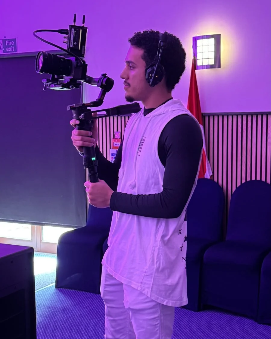 A camera operator filming with a handheld rig