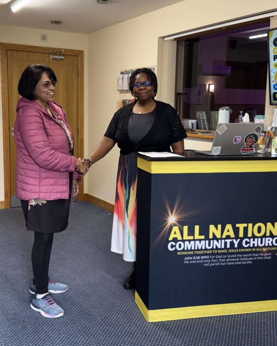 A member of the welcome team greeting a guest at the welcome desk