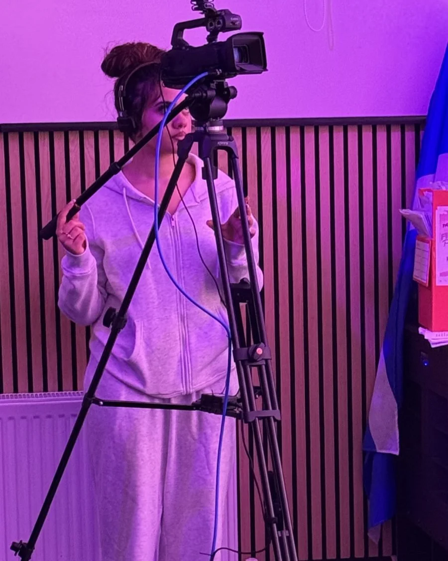 A volunteer operating a camera on a tripod