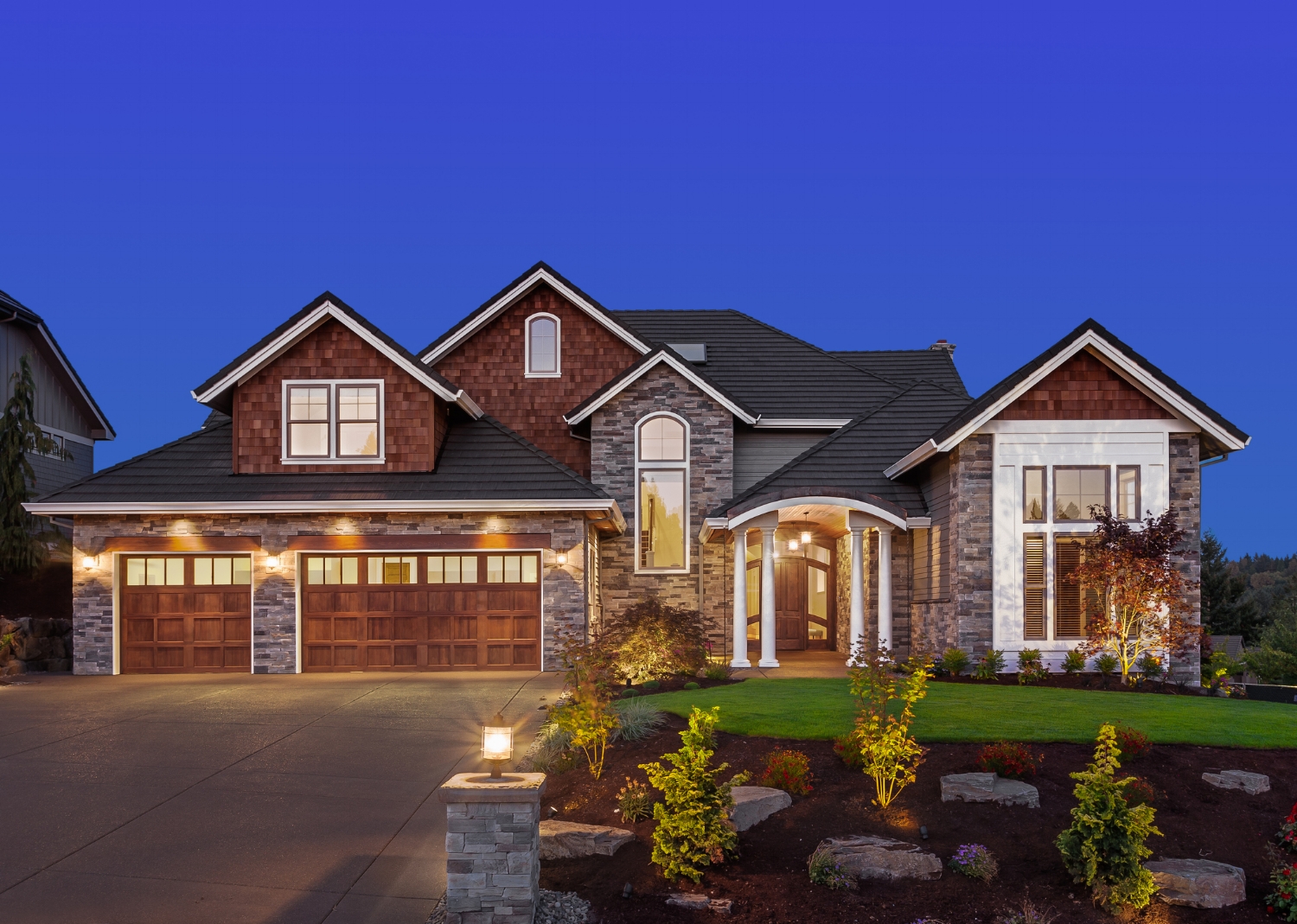 twilight photo of a beautiful home with a great landscaped yard.