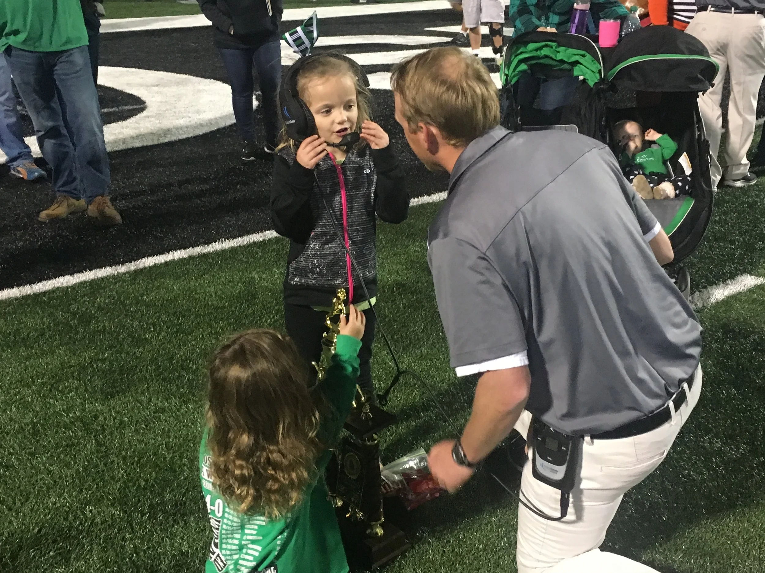 Coach Ford taking time with his daughters after a Roswell win.