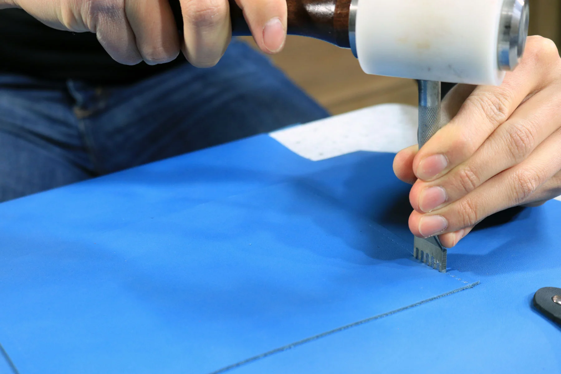 Tooling the leather tote bag with a diamond chisel and mallet