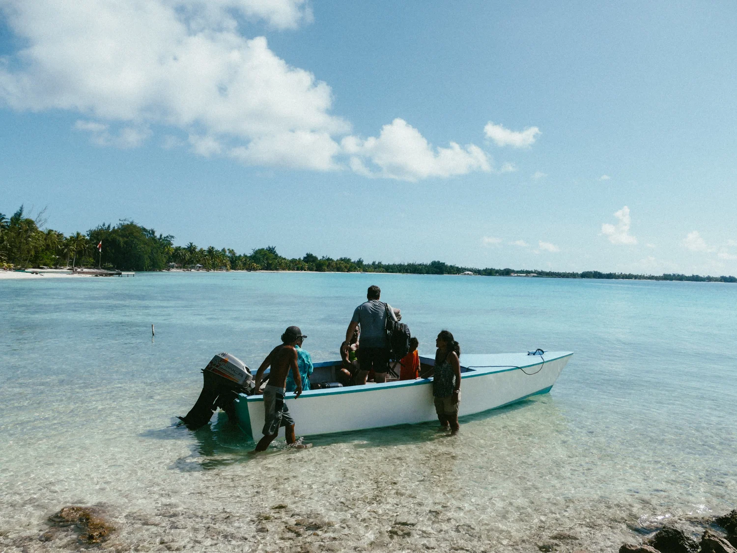 People getting in a boat on Tikehau, Tuamotus, French Polynesia, South Pacific.