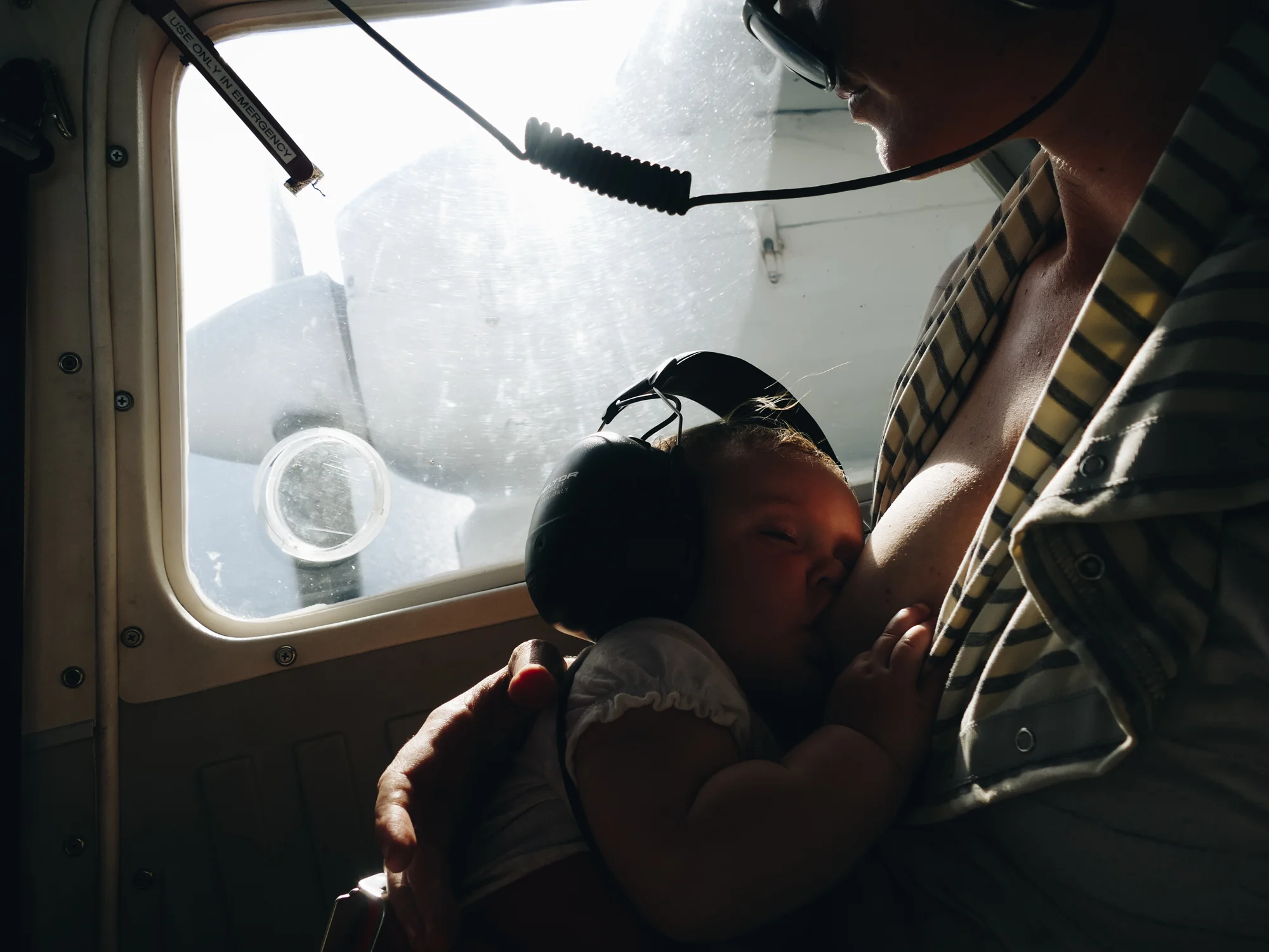 Breastfeeding baby in airplane over Vanuatu, Melanesia, South Pacific.