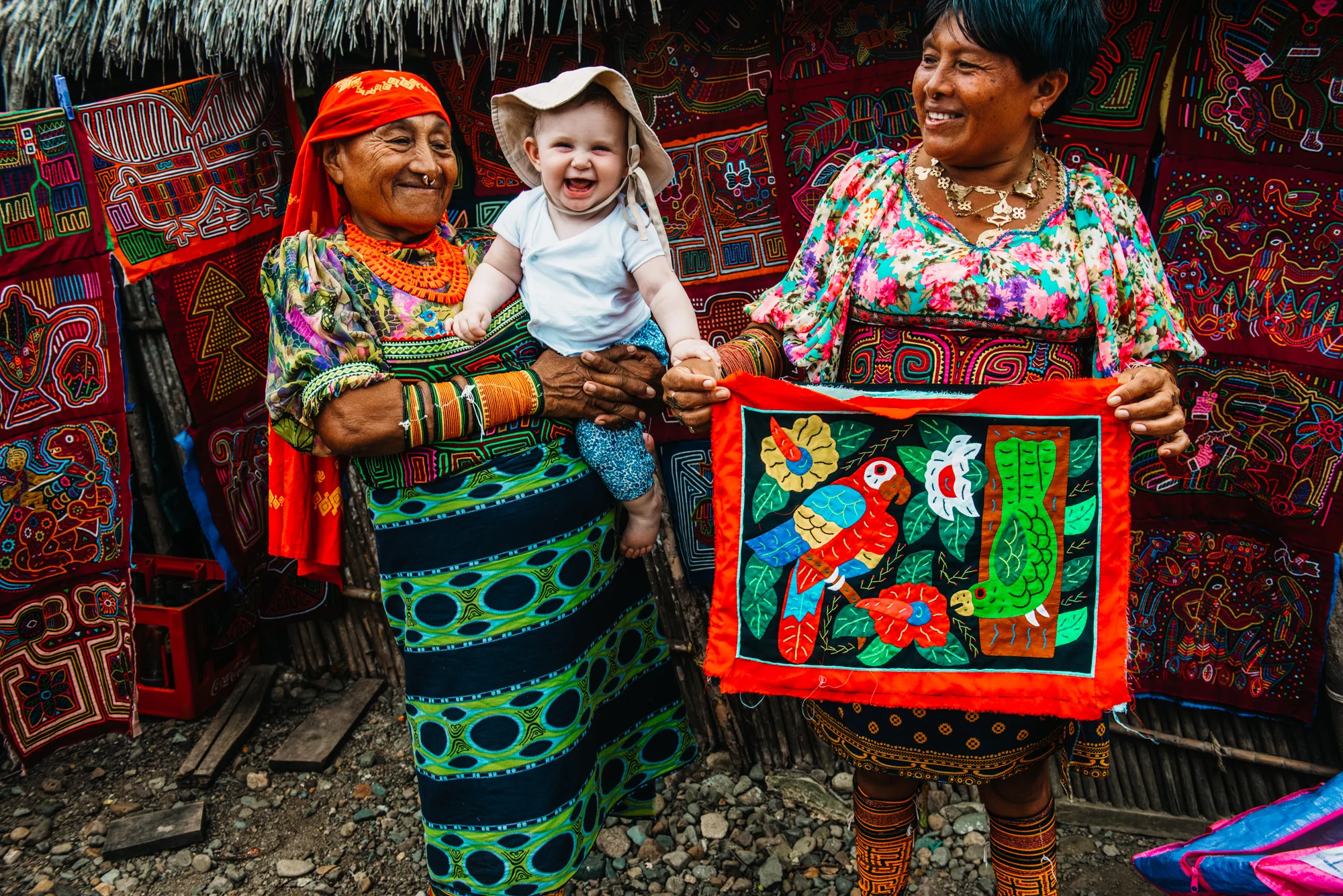 Tradfitional dressed Kuna indian woman holding a white baby, Achutupu, San Blas islands, Kuna Yala, Panama