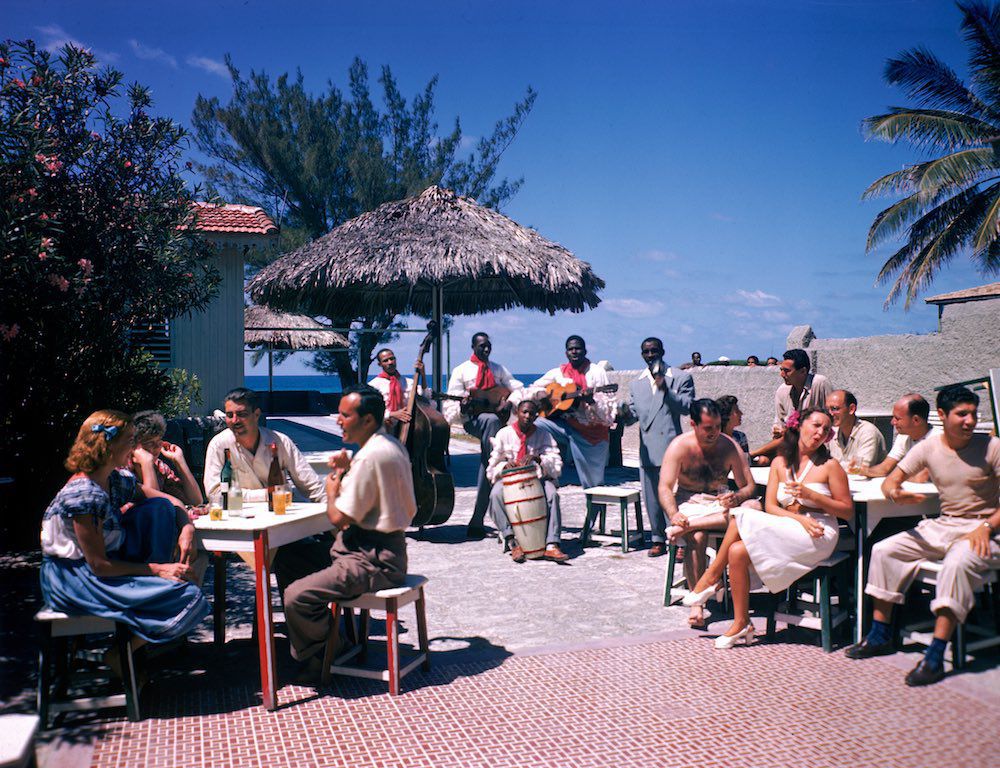 1946 Guests sit at outdoor tables in the Kastillito Club and talk together while a band performs in Varadero, Cuba.