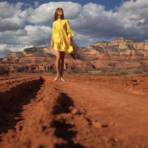 Model walking down a red dirt road in the Arizona desert - Vogue Magazine 1968