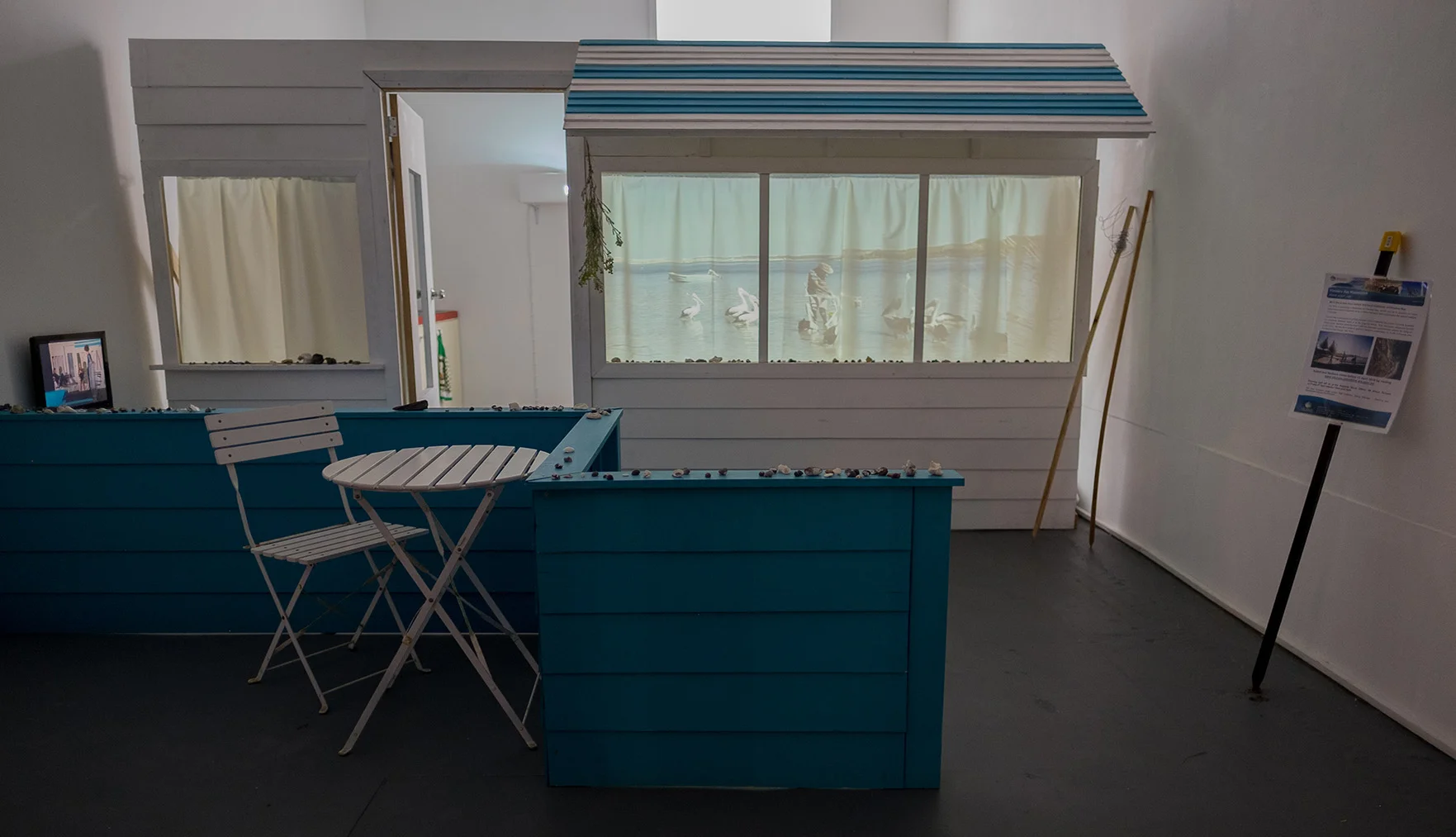 L-R Scene: After the Burnout , 2015, Video, 3 variations of on the same scene, timing varies. 19 Davies Road, Flinders Bay (northwest facing wall) , 2015, Theatre set The Pelican Man feeds the pelicans. He uses an ironing board as a table and throws the left over bits and pieces from his recent catch to the birds / “If you kill a pelican the sky come out with the storm.”- Finger Bone (Storm Boy 1976) , 2015, Video projection, looped “It will be good to have some more barbeques, we’ve only got that one” (said a woman standing next to me, while we look at the sign) , 2016, Augusta Margaret River Shire public notice sign, previously installed at the Swimming Pool, Flinders Bay