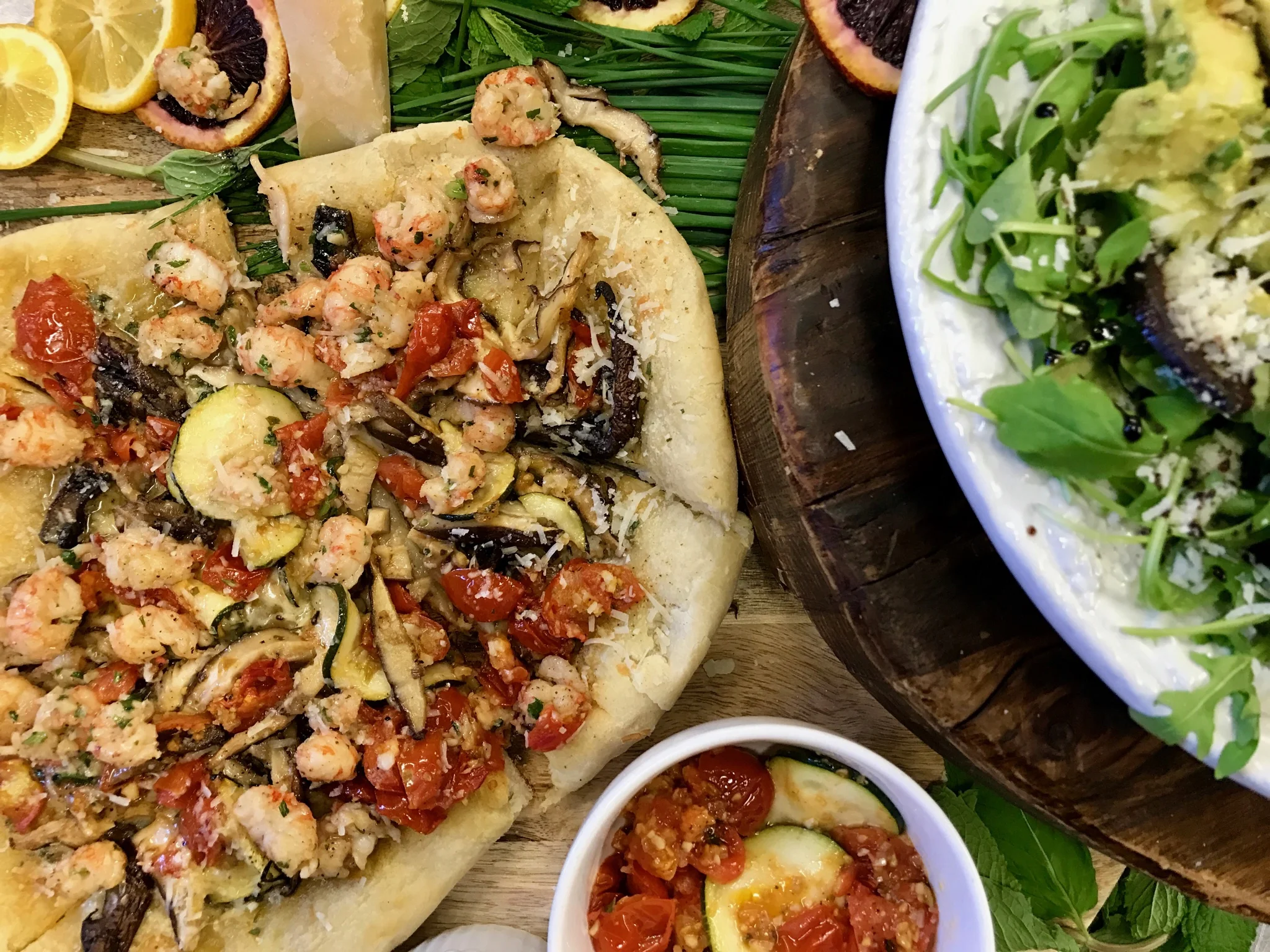 Homemade pizza with lobster, reggiano cheese, tomato, zucchini, garlic, shallots, and shiitake mushrooms.