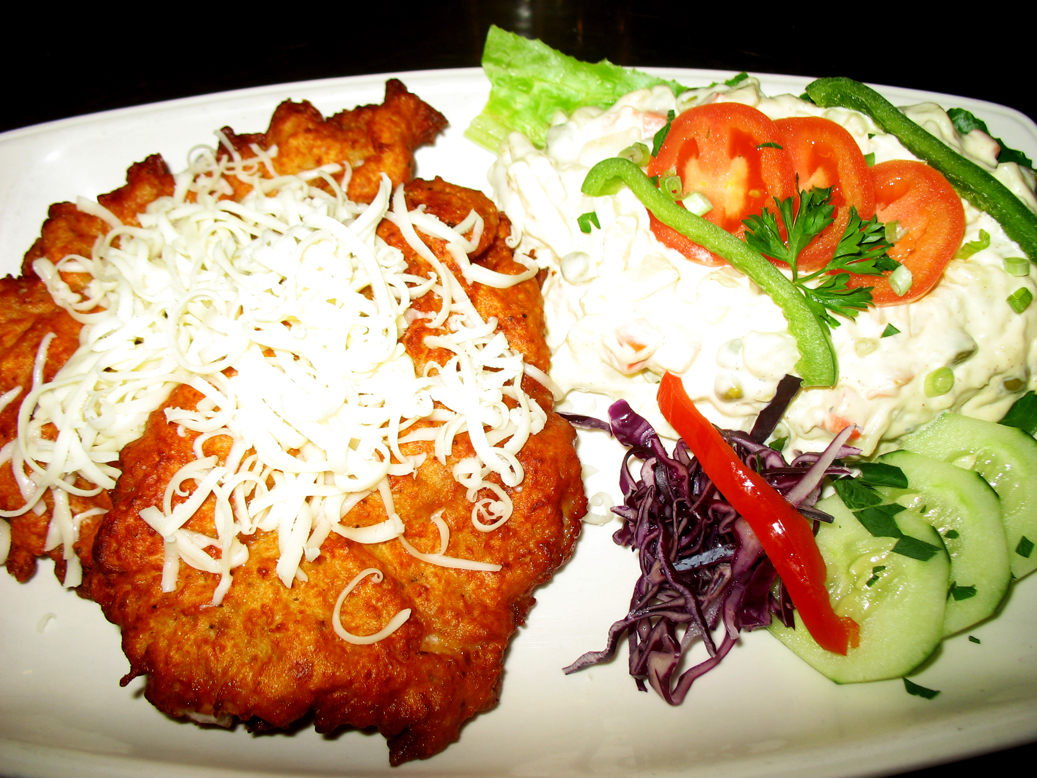 Pork schnitzel in potato pancake batter-topped with cheese with potato salad