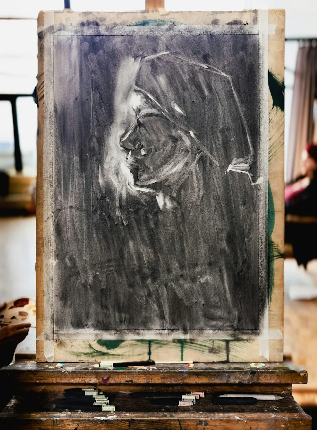 Black and white painting of a person and a woman kissing on a canvas,