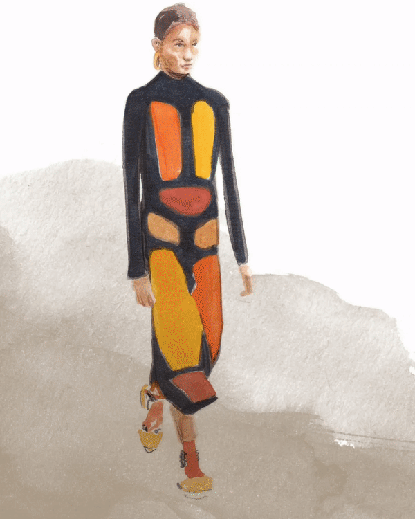 A woman walking on a runway wearing a colorful, abstract patterned dress with black outlines and yellow, orange, and beige sections.