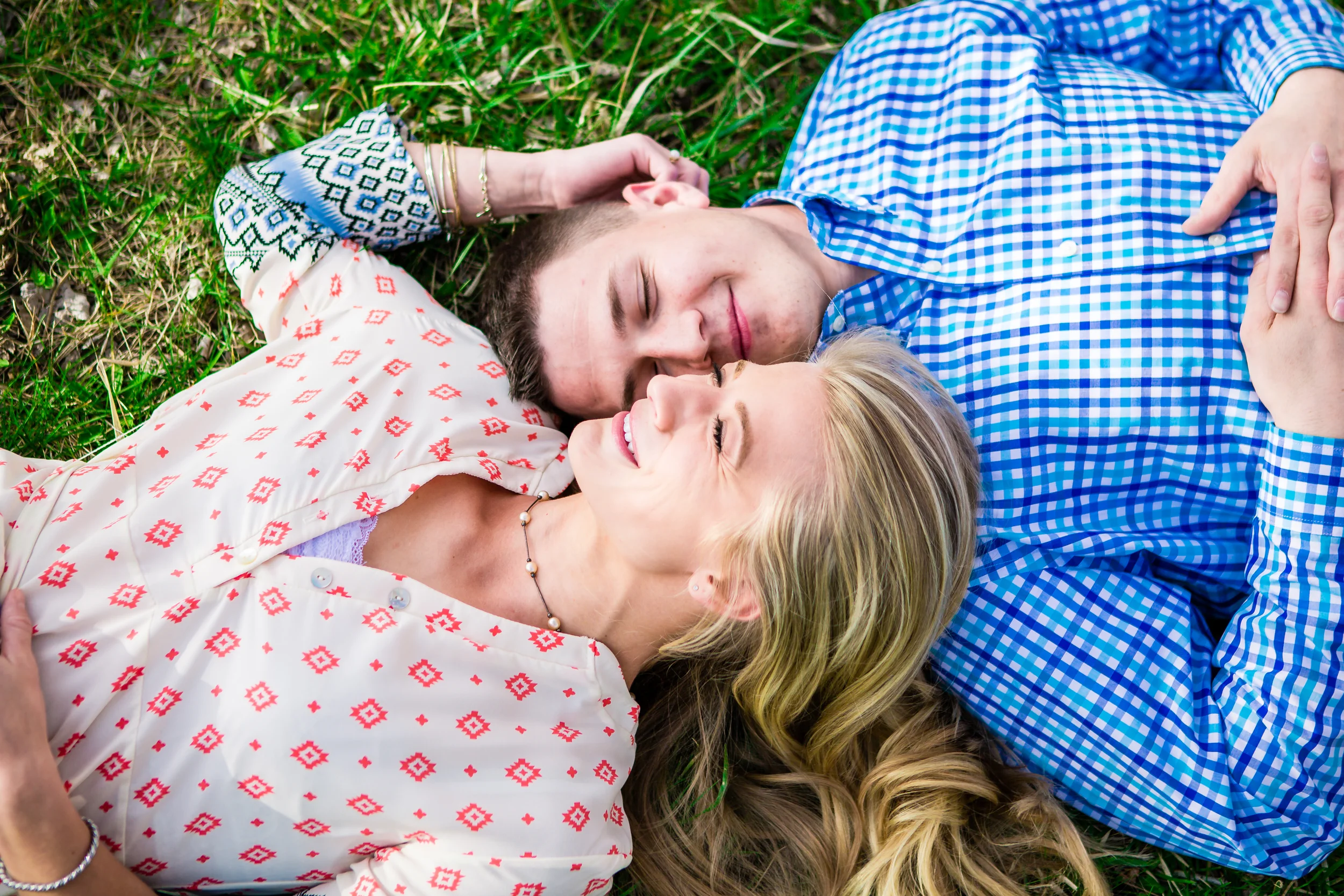 Couple laying in the grass. Engagement taken at Lions Park in Fort Collins Colorado by Jared M. Gant