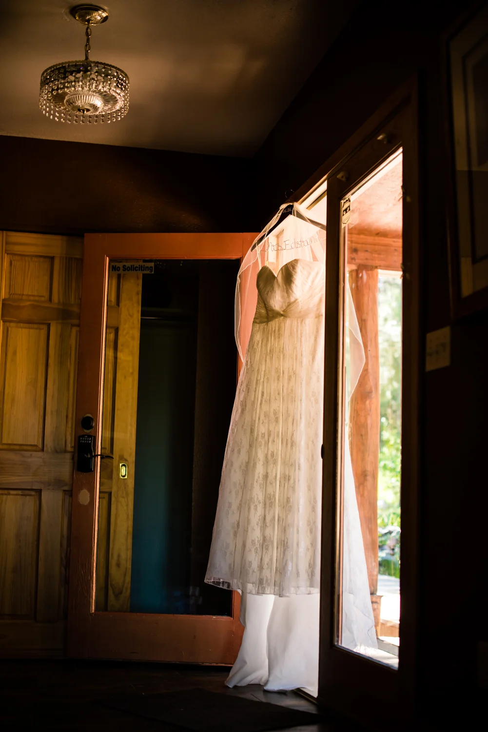 Wedding dress hanging in doorway for a Deer Creek Valley Ranch Wedding. Photographed by JMGant Photography.