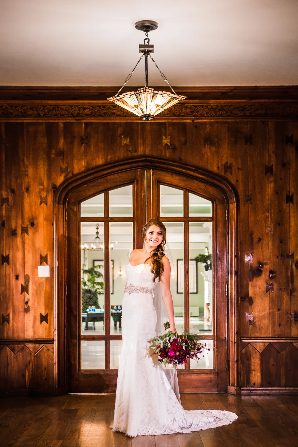 Bride in front of wood doors at Highlands Ranch Mansion. Photographed by JMGant Photography.