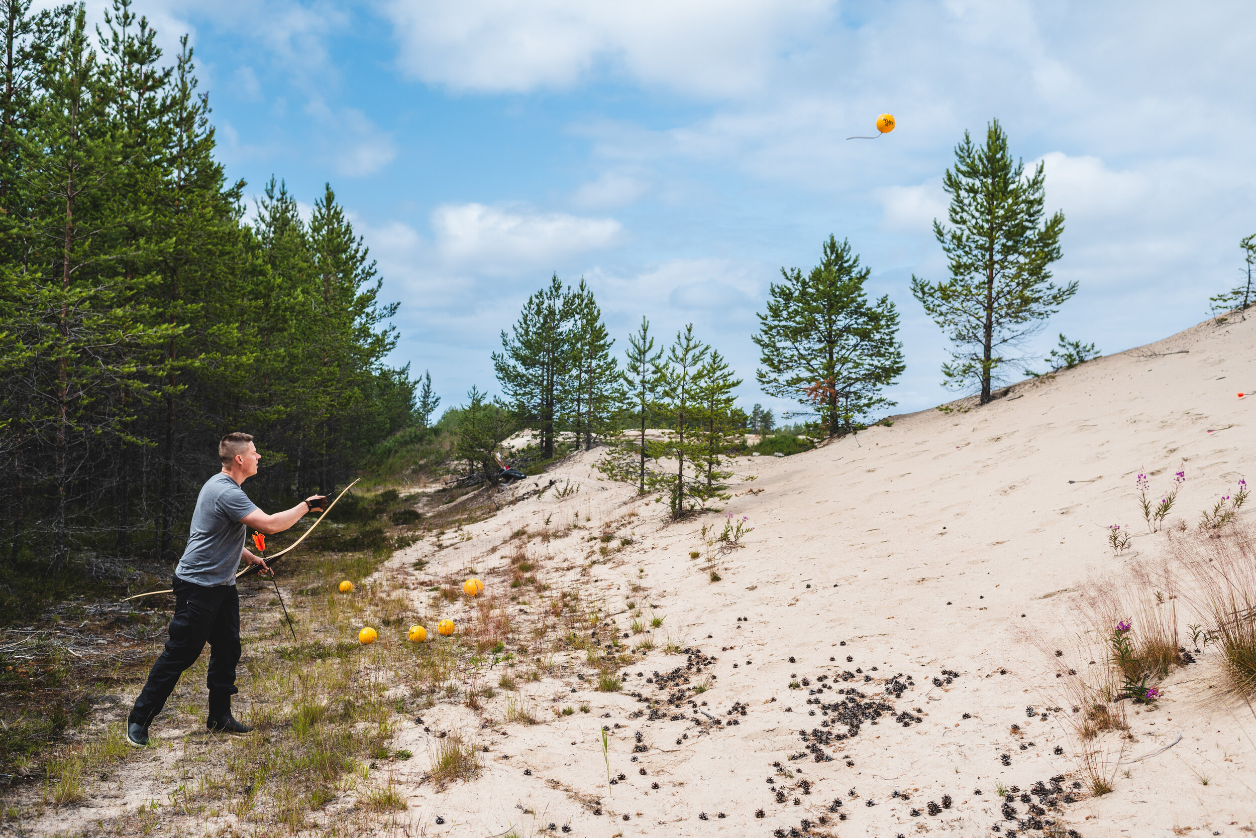  Haukipudas, Oulu 2019. A man was training hunting with a bow and arrow. He threw balls onto a gravel pit slope and tried to hit moving targets. 
