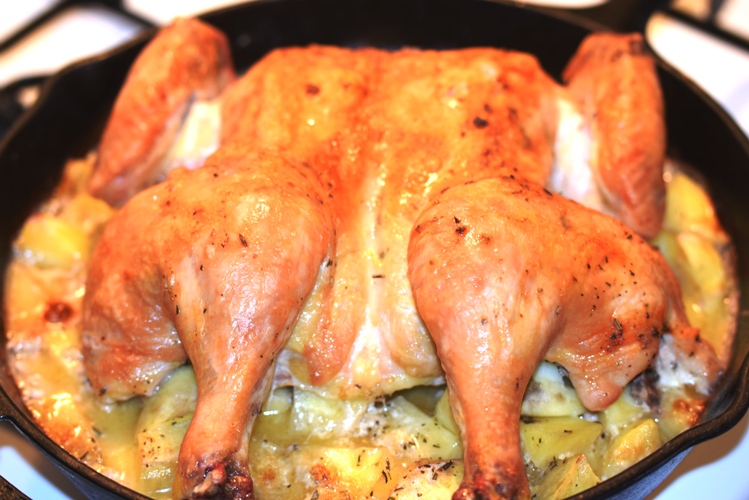 Butterflied Roast Chicken with Herbs de Provence sitting on the Roasted Potatoes that will soon be smashed for a delicious side to the chicken.