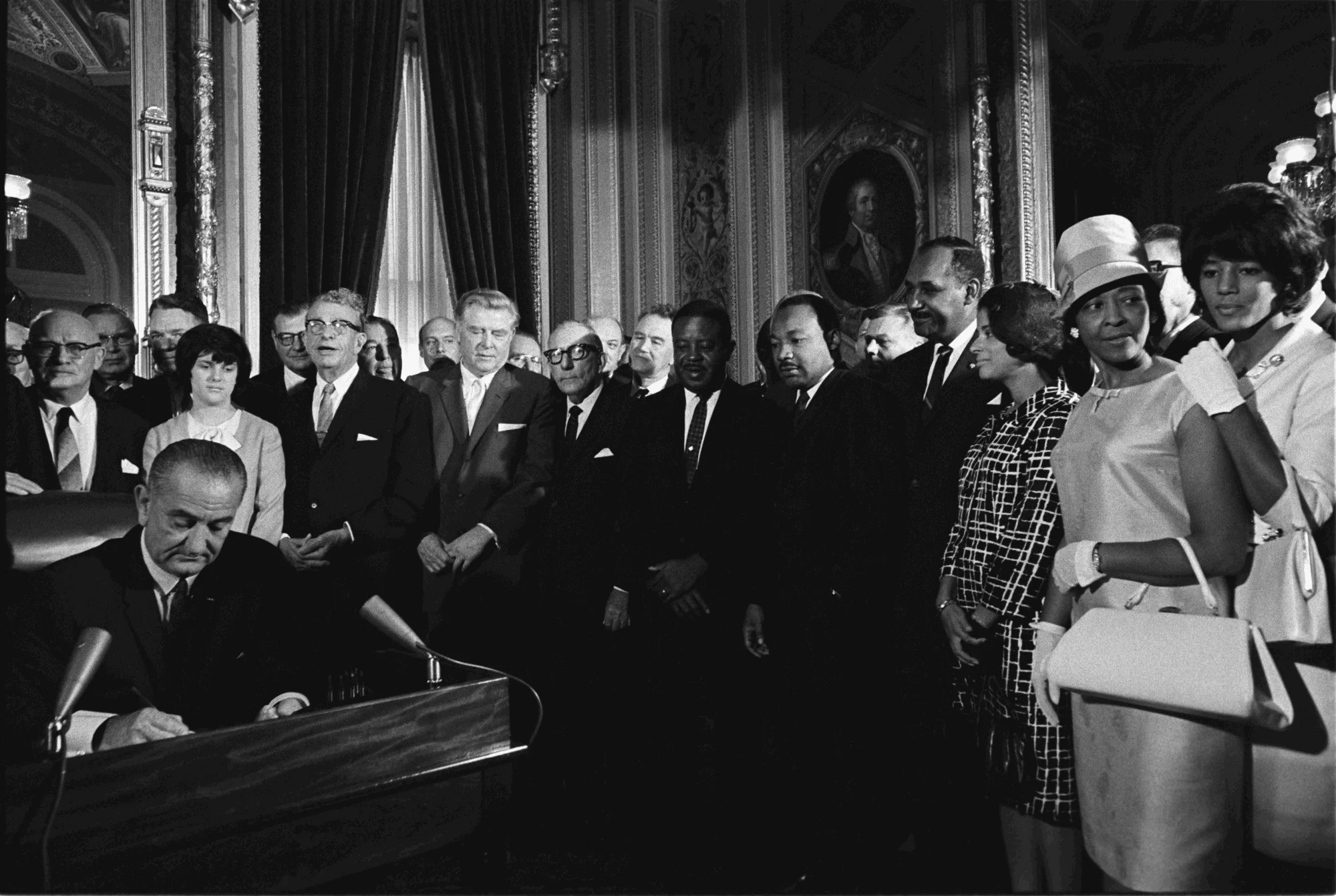 President Lyndon B. Johnson signs the Voting Rights Act of 1965 while Martin Luther King and others look on. LBJ Library photo by Yoichi Okamoto.