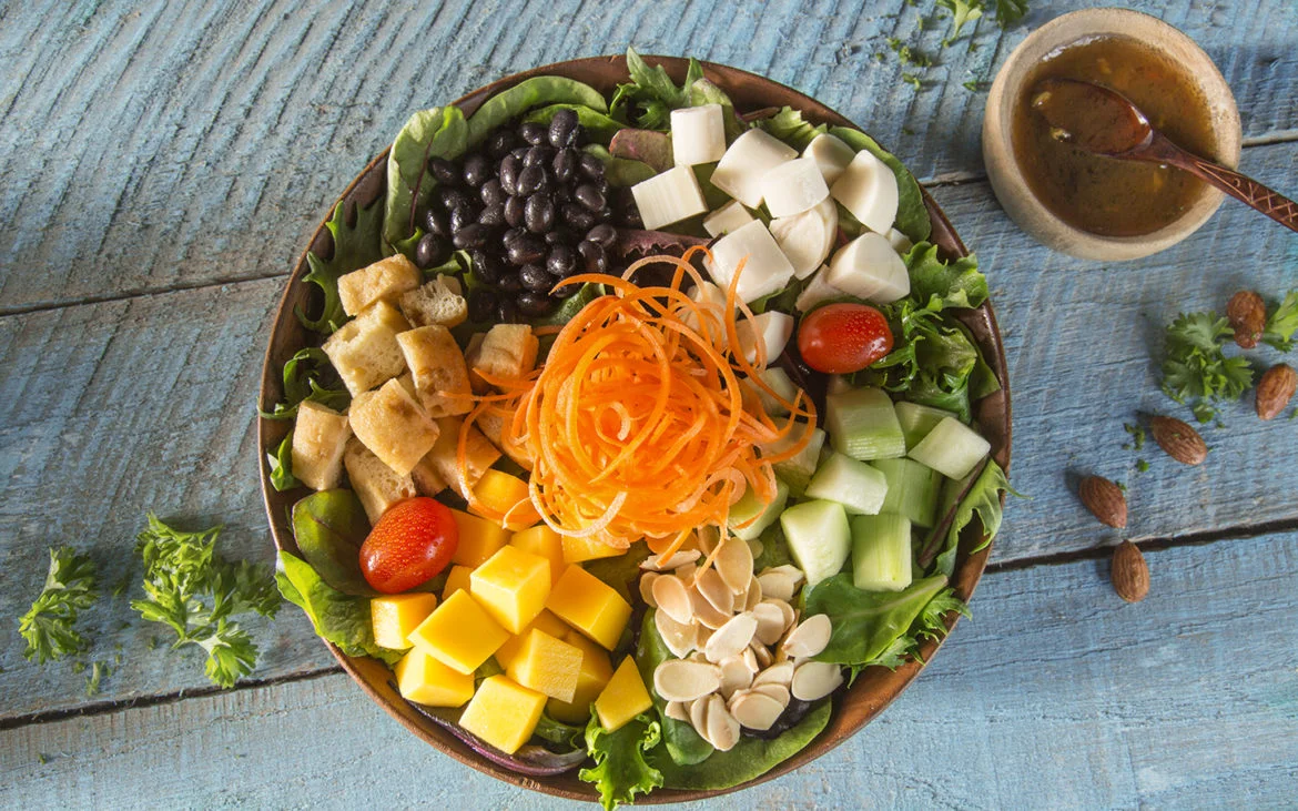 Tropical Baby Greens with Shaved Carrots, Hearts of Palm, Diced Mango, Grape Tomatoes, Cucumbers, Tofu, Black Beans, Toasted Almonds and Soy Garlic Vinaigrette. Image credit: Universal Orlando Resort. 