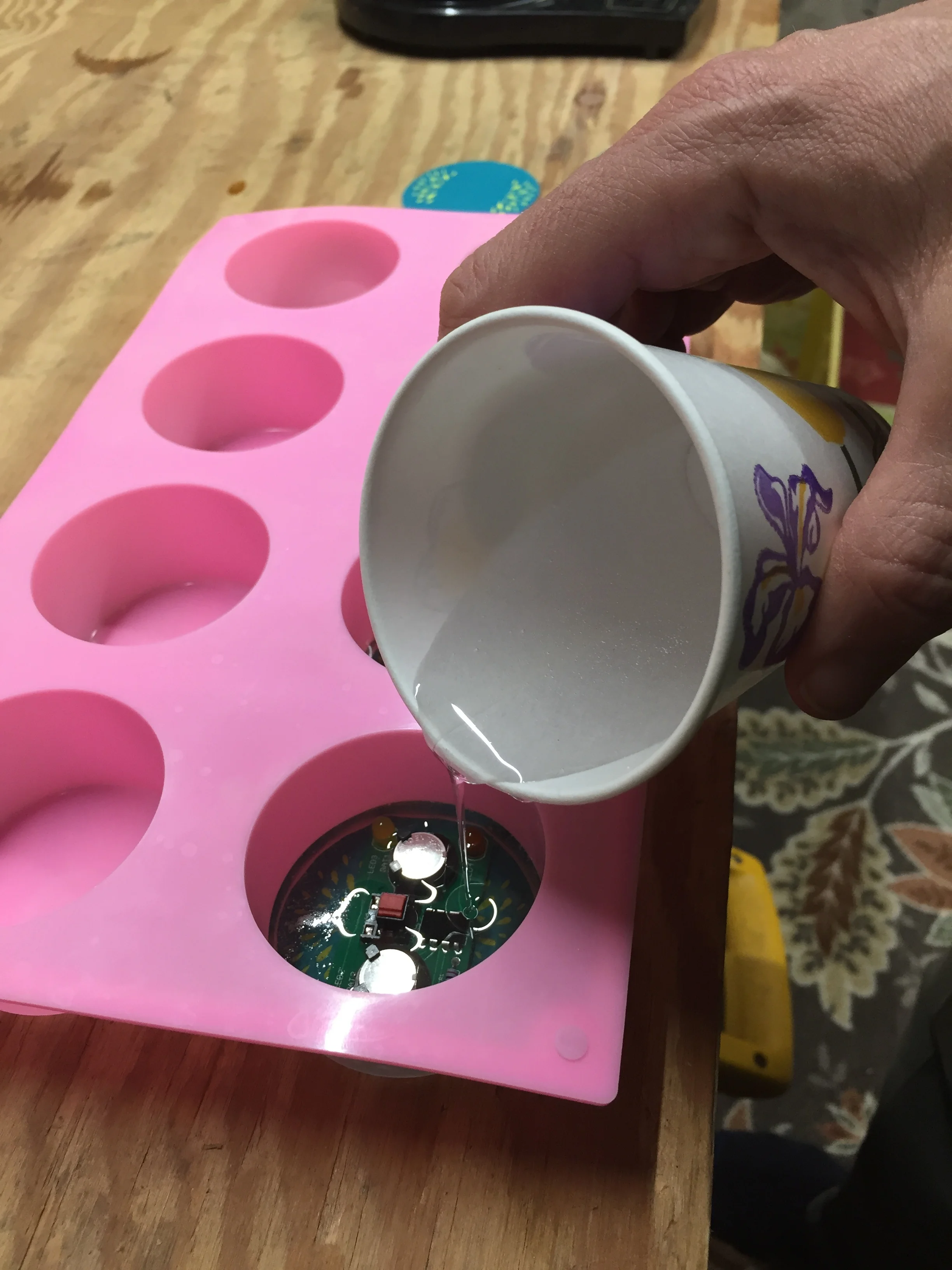 Pouring epoxy into the molds to encase the Two Minute Turtle Timer