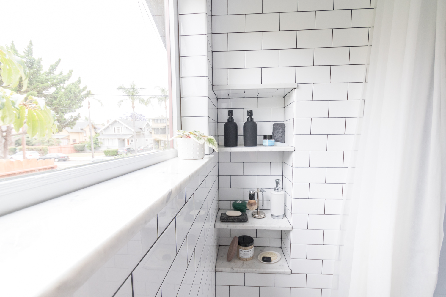 Marble sill and shelves in shower subway tile
