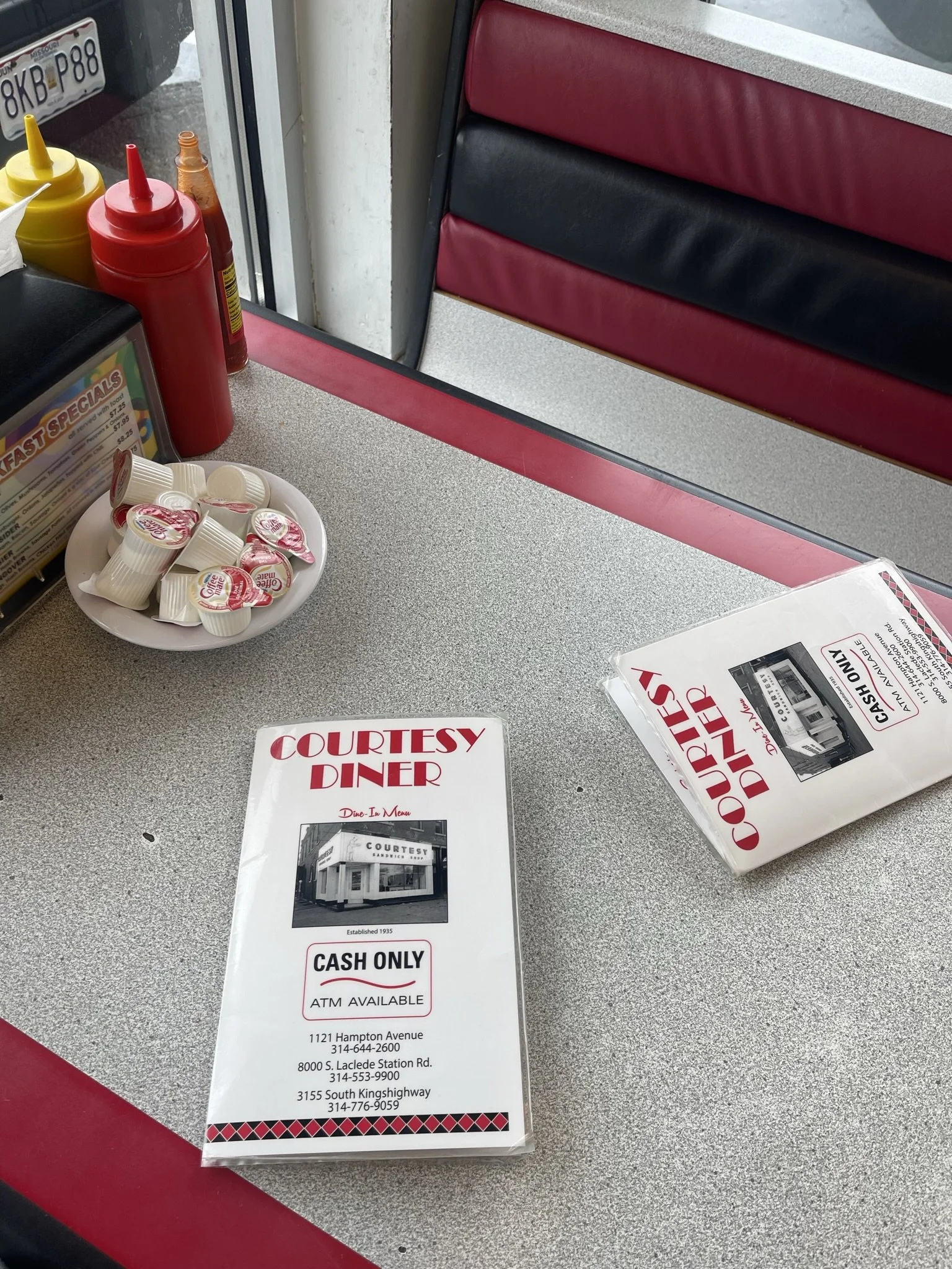Diner booth with red vinyl seats, menus and condiments.jpeg