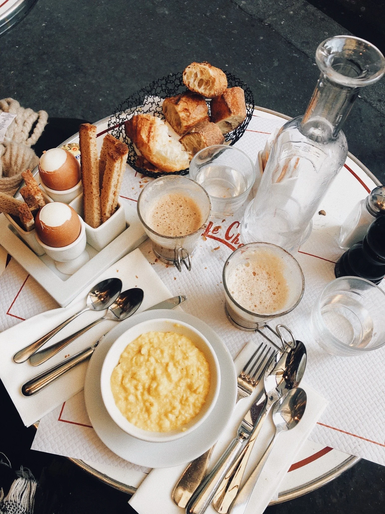 Overhead cafe breakfast of soft-boiled eggs, pastries and coffee on a bistro table.JPG