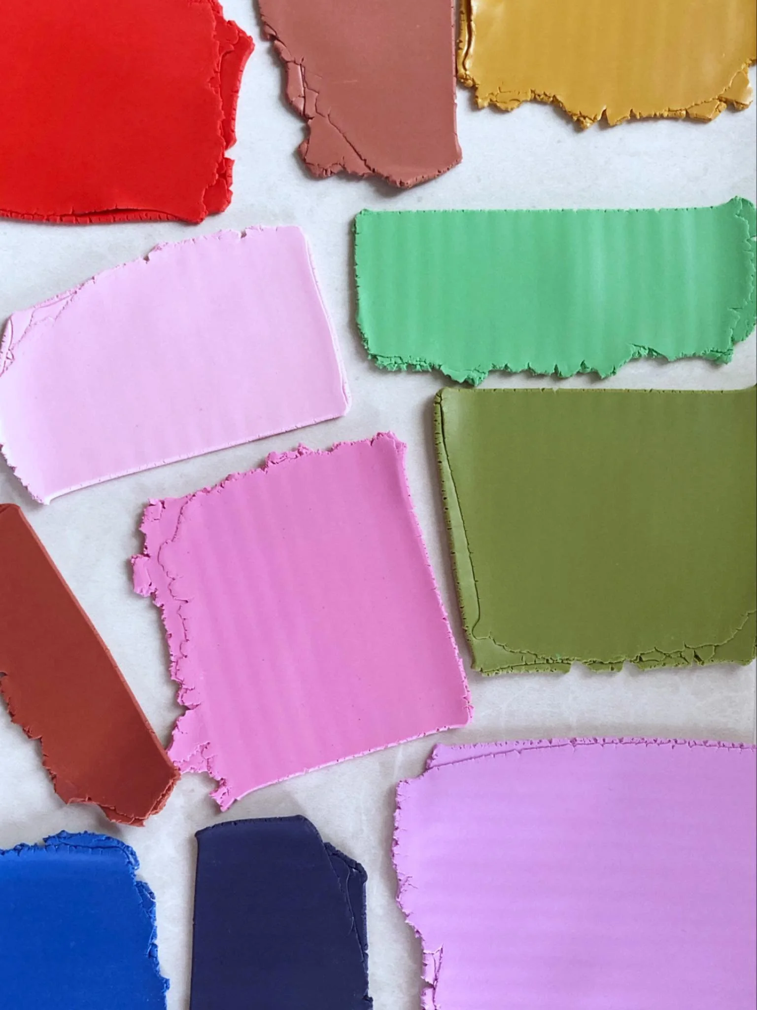 Pinks, greens, and blues, oh my. 

Working on a thing that will use up a chunk of my scrap clay. Before using the clay, it needs to be conditioned, which means running it through my pasta machine over and over until it sticks to itself and stops crac