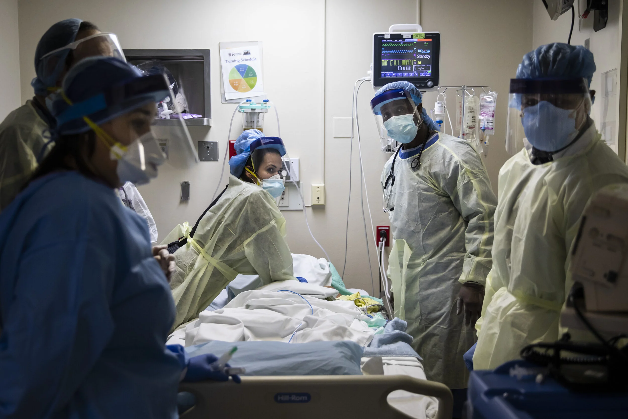  Respiratory therapist Khafran Alshahin (center) watches the monitor for a heart rhythm while performing chest compressions on an 80-year-old man who would shortly thereafter die of complications from COVID-19 in the Intensive Care Unit at Roseland C