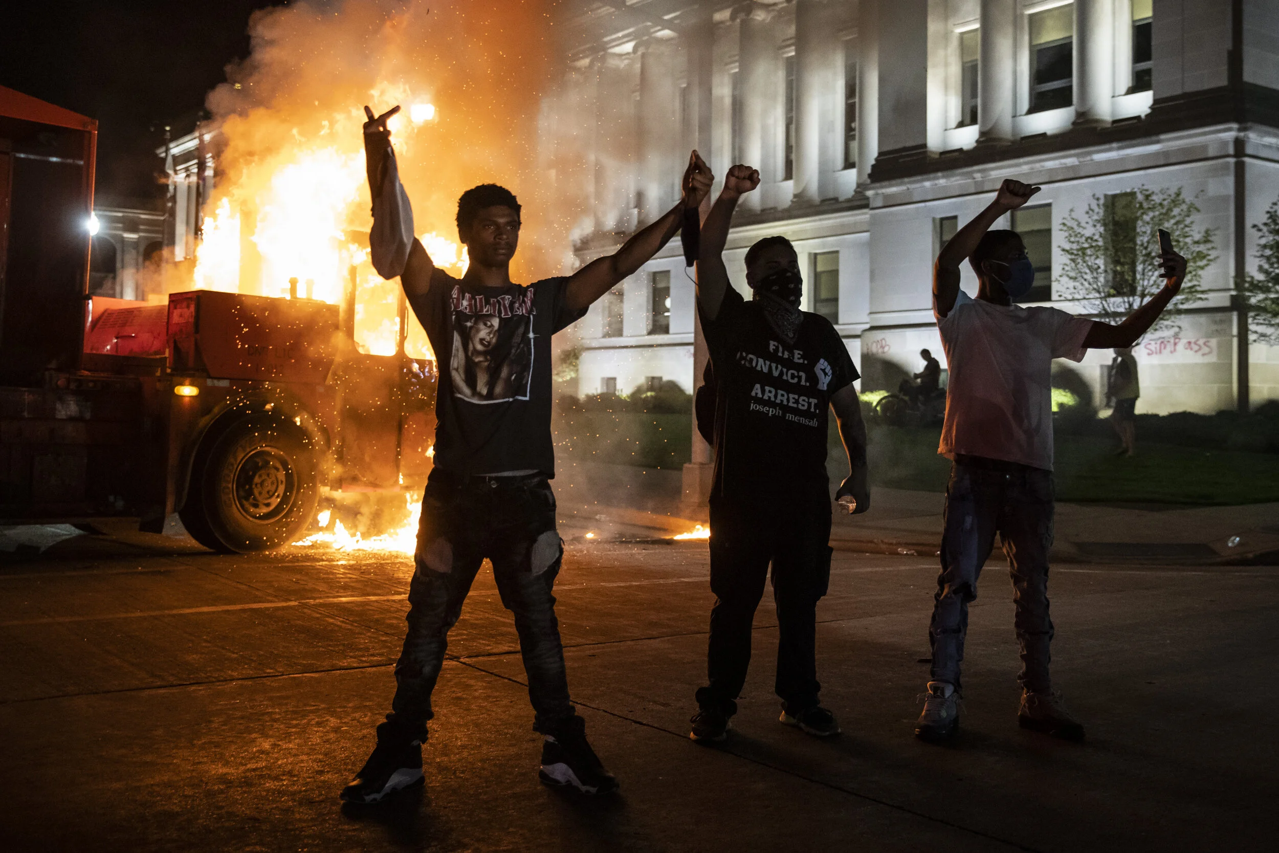  Protesters stand near a burning truck outside the Kenosha County Courthouse, where law enforcement clashed with Black Lives Matter protesters and others in the second night of unrest after a police officer in the Wisconsin city shot Jacob Blake, Mon