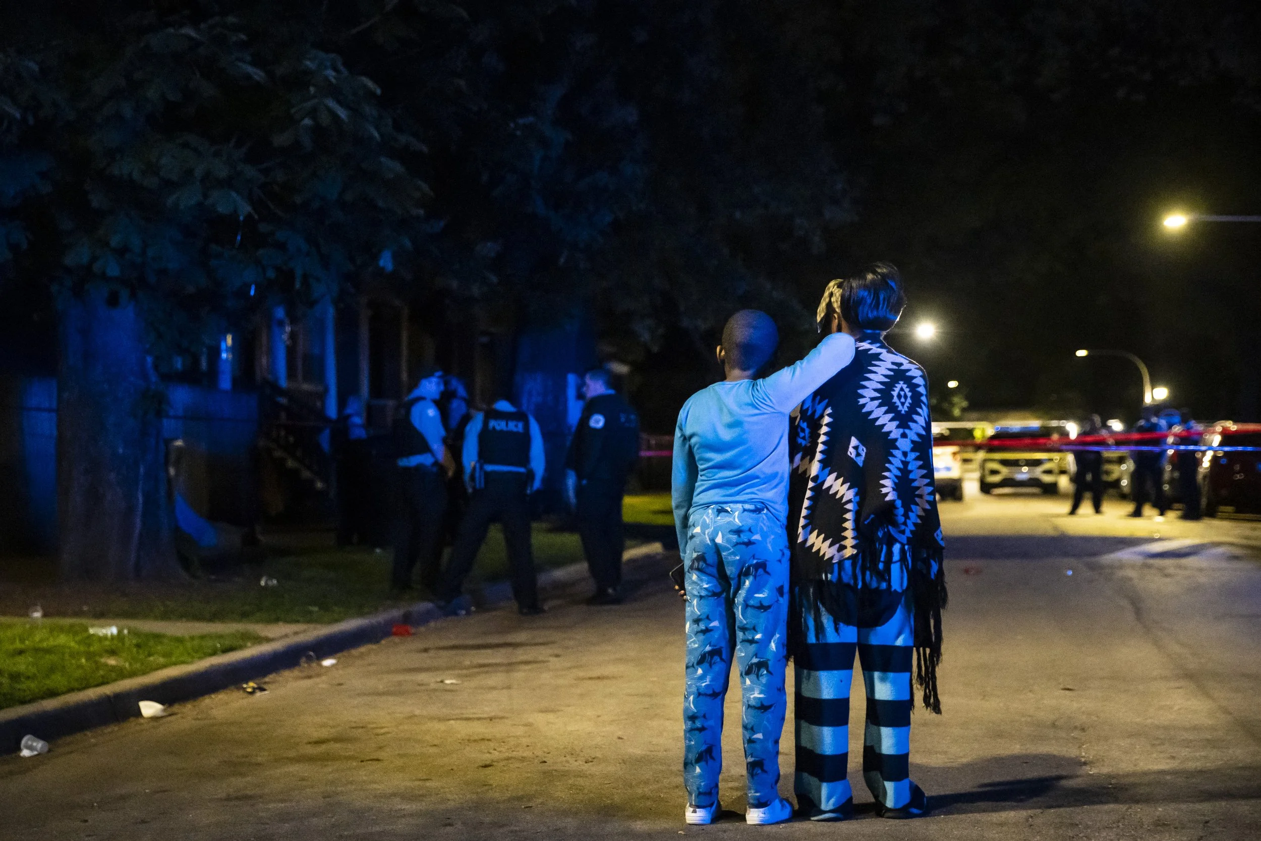  Family members watch as Chicago police investigate in the 5700 block of South Carpenter Street, where 24-year-old Tmario Devonte Boughton was shot to death during a party on the Englewood neighborhood block on the South Side, early Sunday, May 29, 2