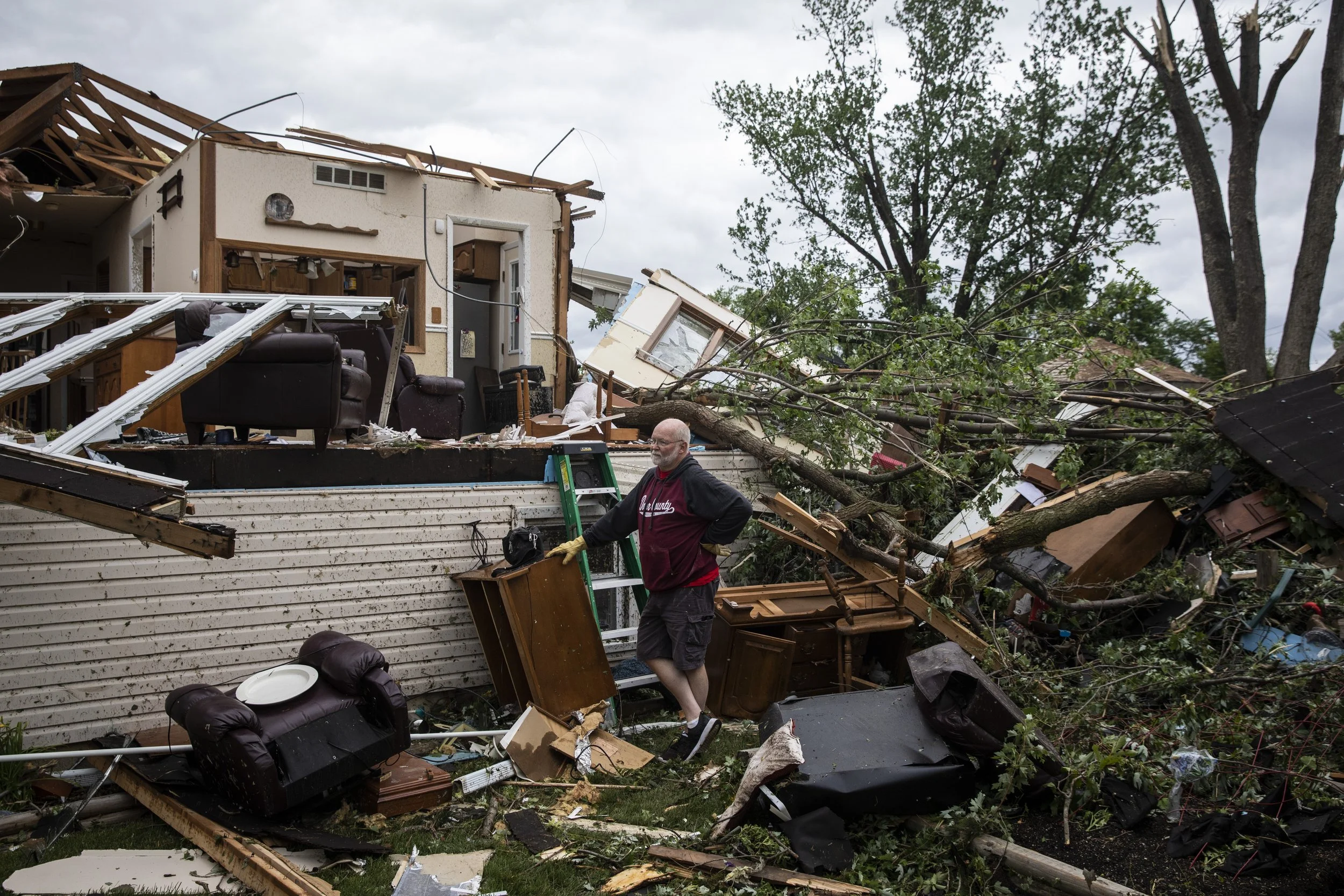  Mike Baar, 70, of Dixon, takes a break to look around while helping to clear out his sister-in-law's house on Janes Avenue near Evergreen Lane in Woodridge after a tornado ripped through the western suburbs overnight, Monday morning, June 21, 2021. 