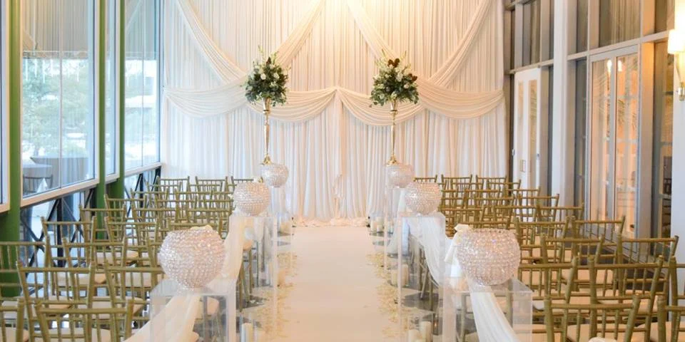 Criss Cross Ceremony Backdrop with aisle runner and ghost pedestals.jpg