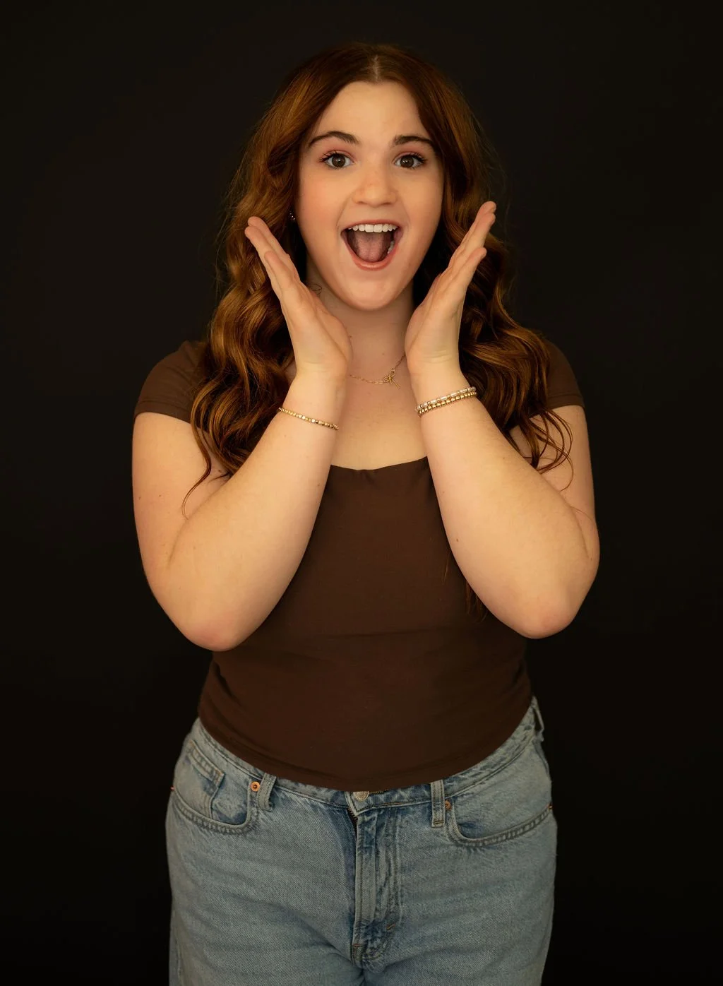 High school senior girl laughing with hands on face during studio portrait session — Denver senior photographer Jennie Bennett Photography