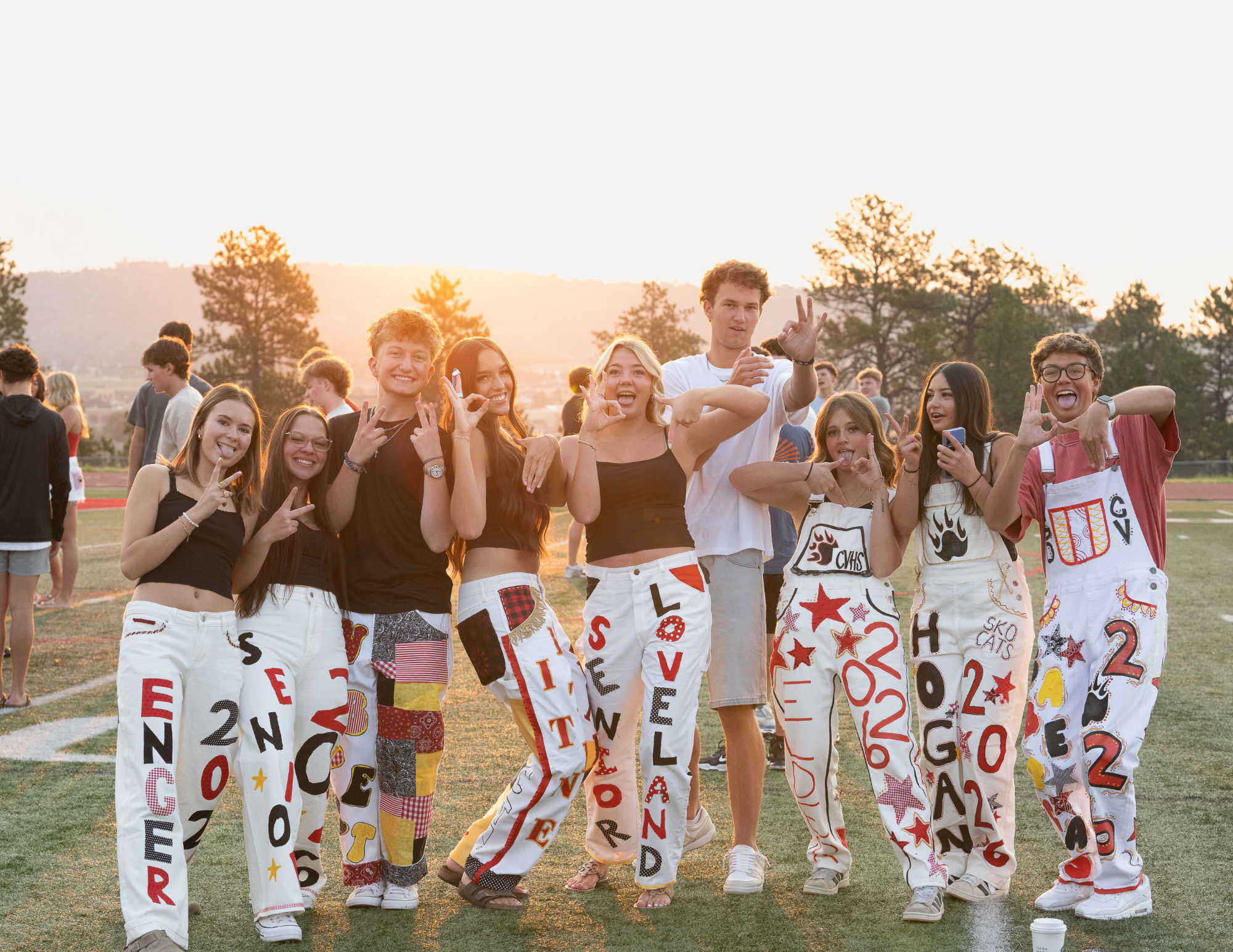 High school seniors at Senior Sunrise 2026 at Castle View High School in Castle Rock Colorado in painted overalls — Denver senior photographer Jennie Bennett Photography
