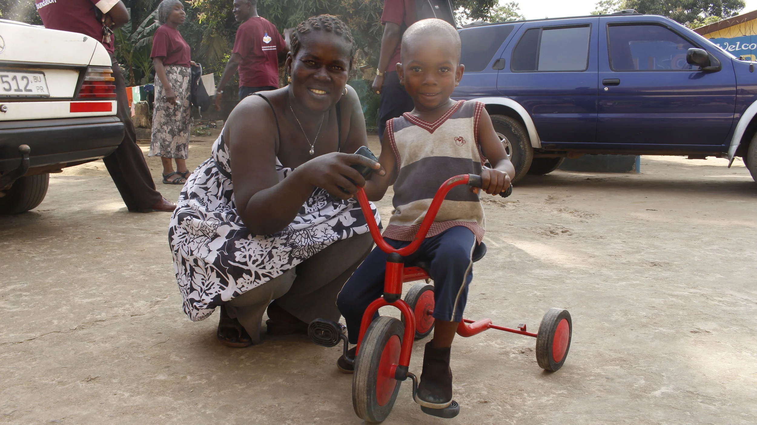  Carer in (A) orphanage Sierra Leone, helping a child with a bicycle NDF donated. 