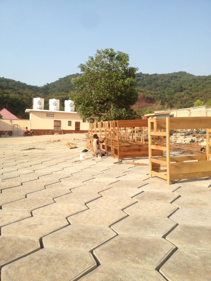 Last coats of paint is put on the handmade bunkbeds for the children and in the distance the clean water tanks can be seen, which will provide the orphanage site with clean drinking water.