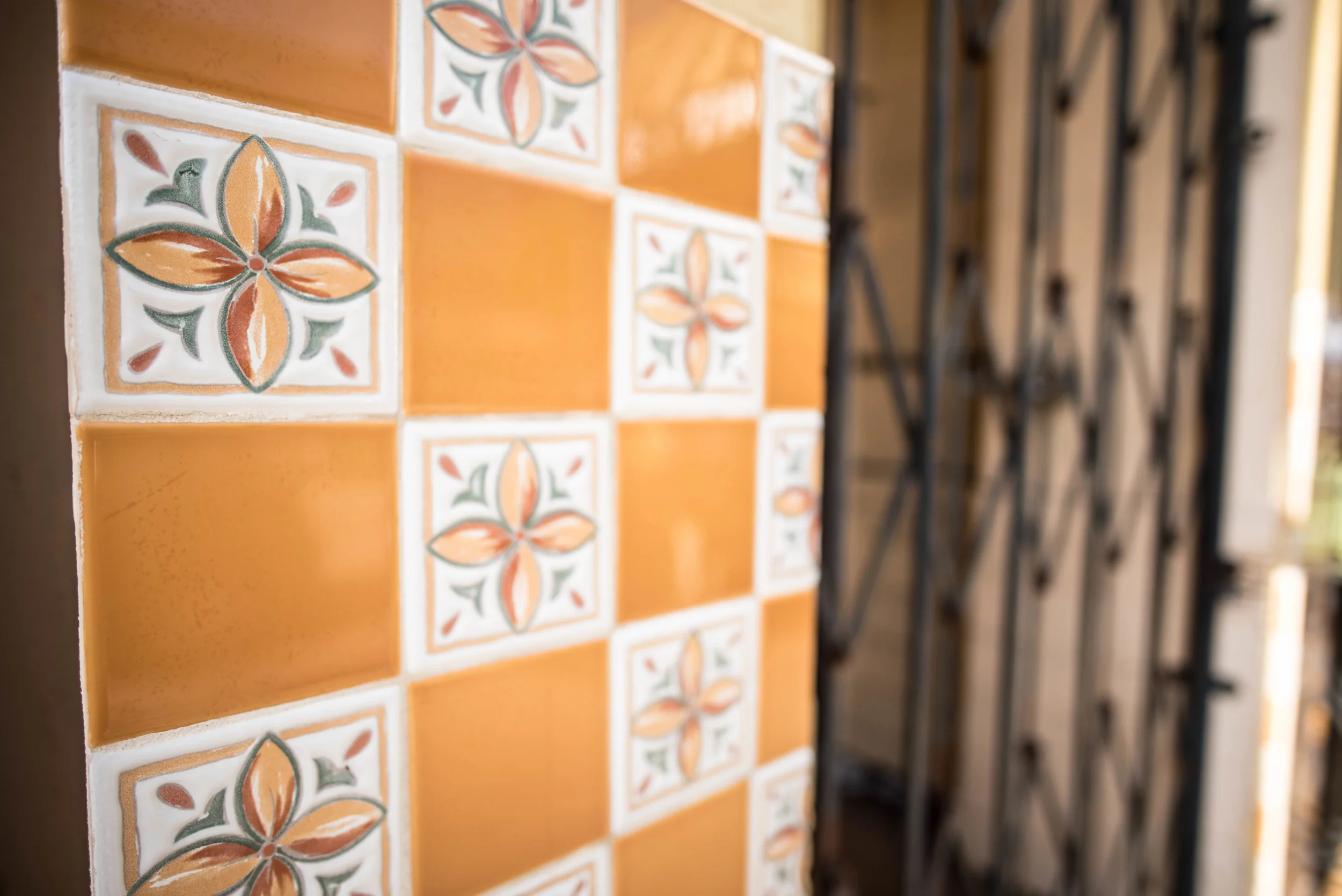 Inviting tiles beside an unwelcoming barred doorway