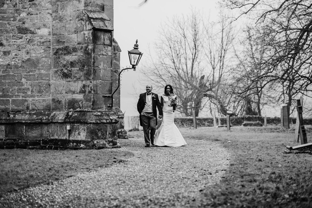 Meisha and Patrick walk hand in hand through the church grounds. 