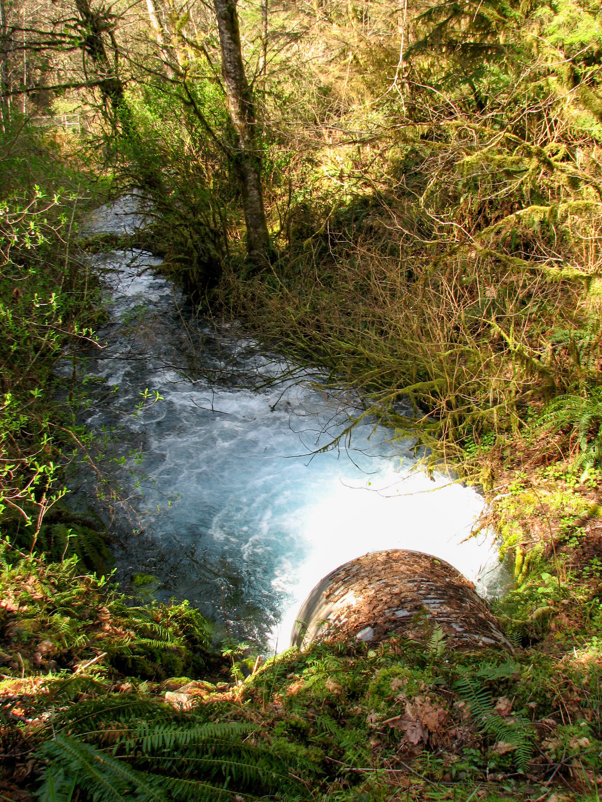 Deep blue water spilling through culvert