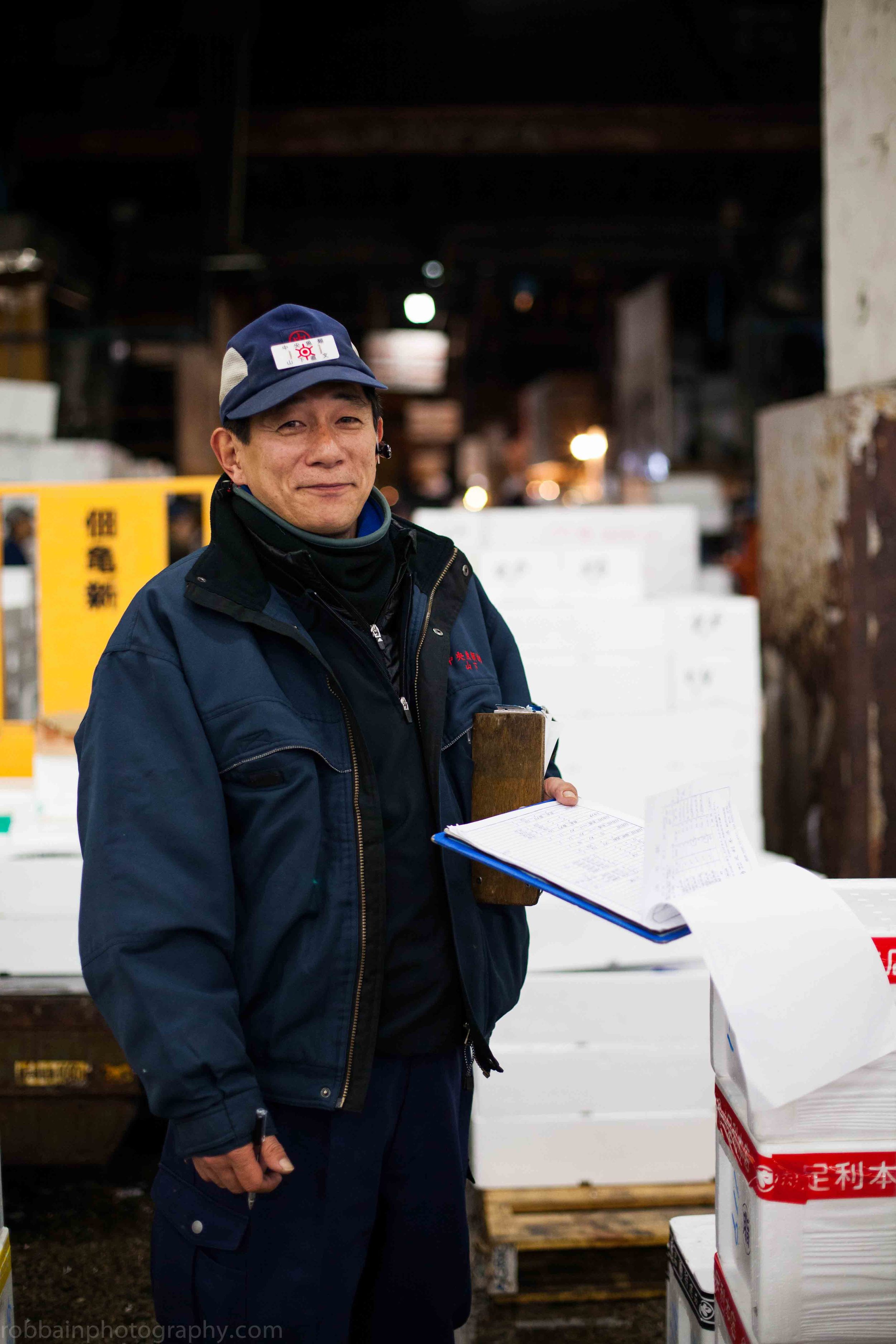 Photo 9. Naofumi Yamashita wearing hat and holds clipboard.jpg