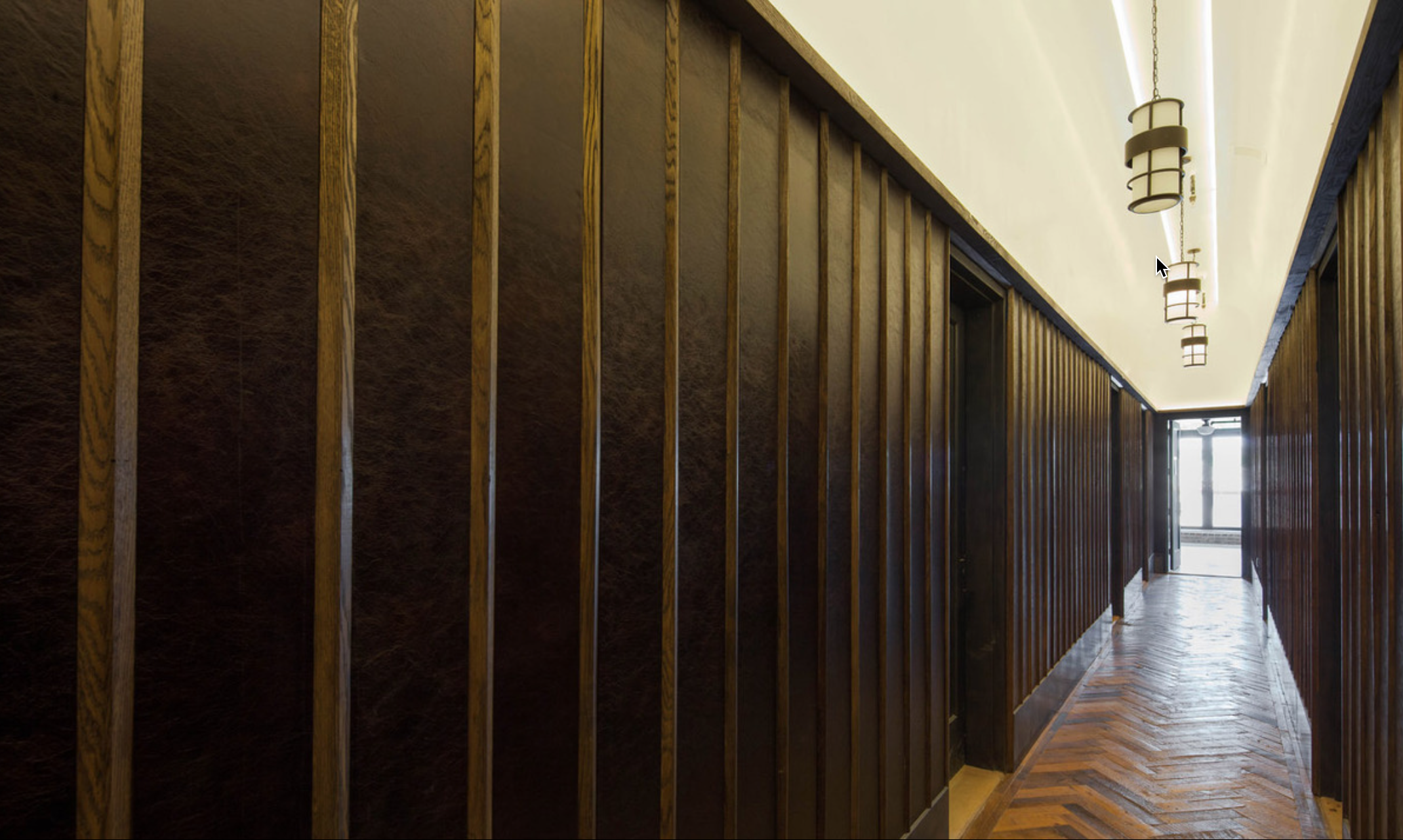 Main hallway of renovated gothic Church on N.6 St. Brooklyn. Flooring wood reclaimed from shipping palettes, wall panels of leather trimmed with oak elements. Lighting design.
