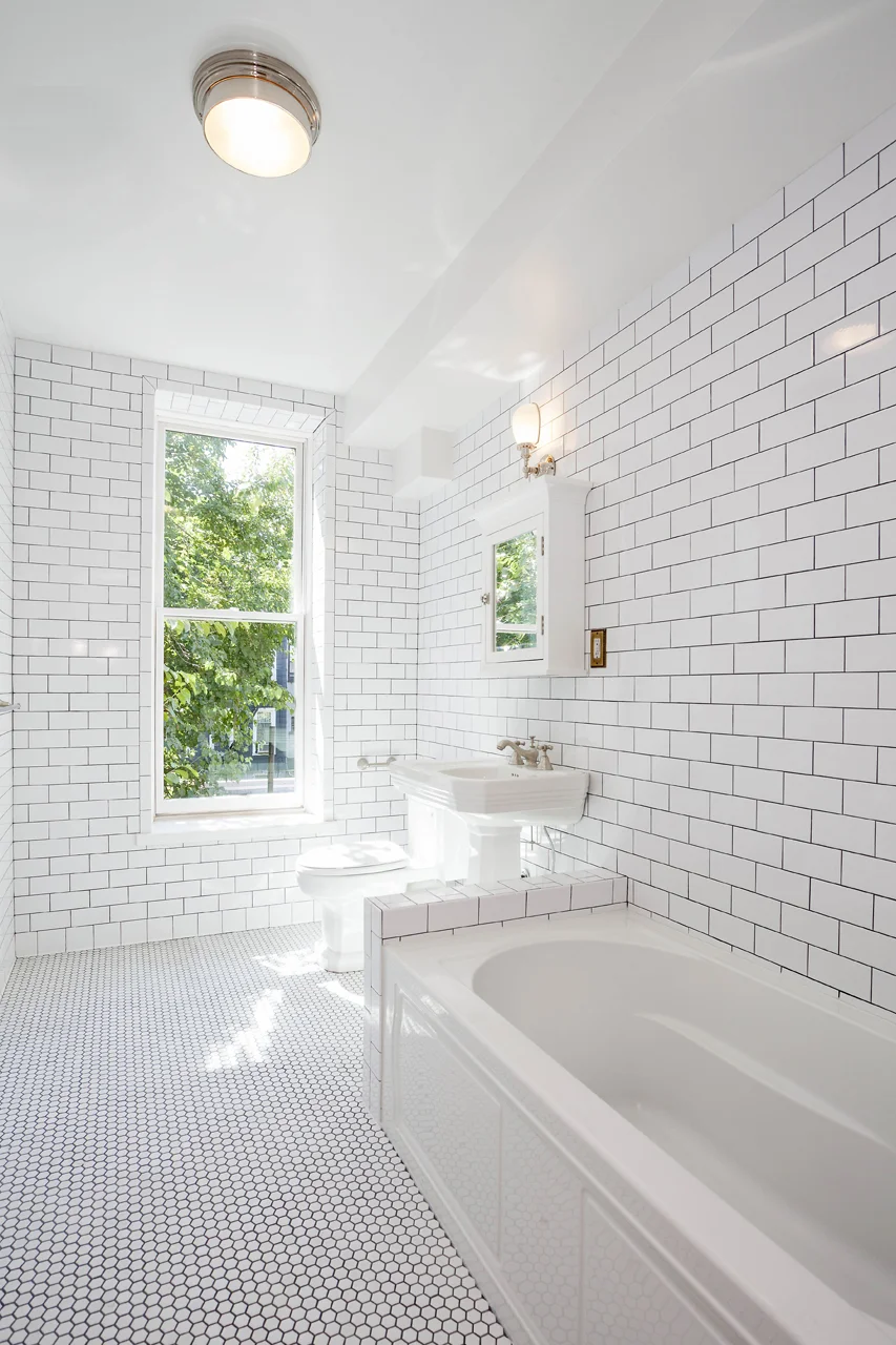 Subway tile bathroom, unglazed hex flooring.