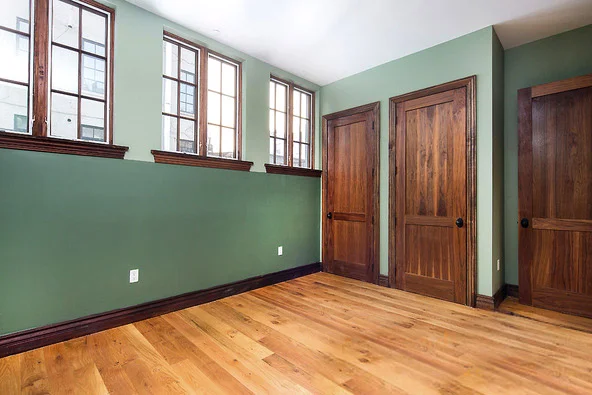 Restored master bedroom, period finishes and colors, wide reclaimed oak flooring, restored repurposed doors.
