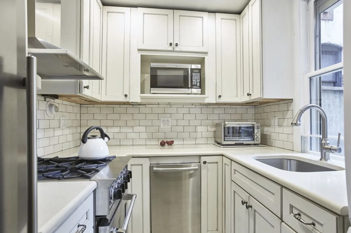 Kitchen renovation in small bed Sty apartment. Crackle subway tile, french grey grout, wide spacers, composite stone counter.