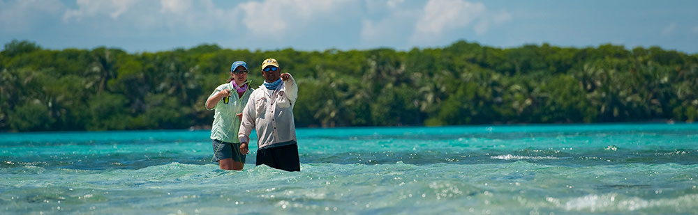 Belize fly fishing guide with angler looking for bonefish, permit, and tarpon at Turneffe Flats.