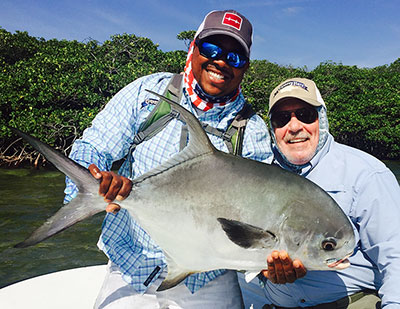 Fly Fishing guide with his client and a big permit caught in Belize