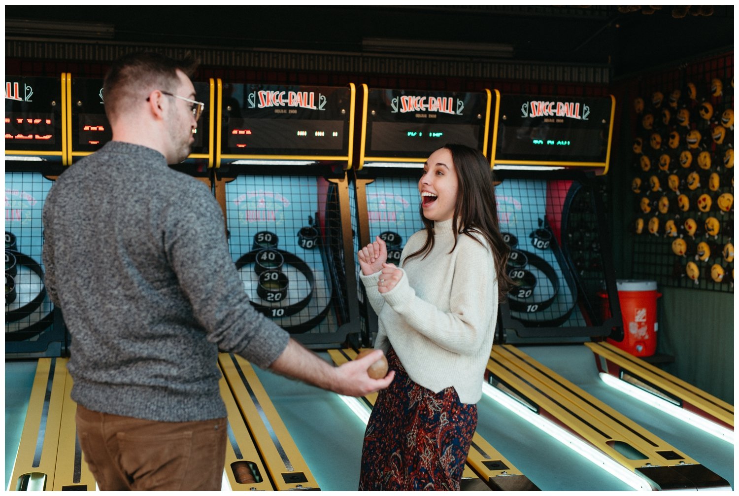 The couple plays vintage arcade games during Atlanta engagement photos