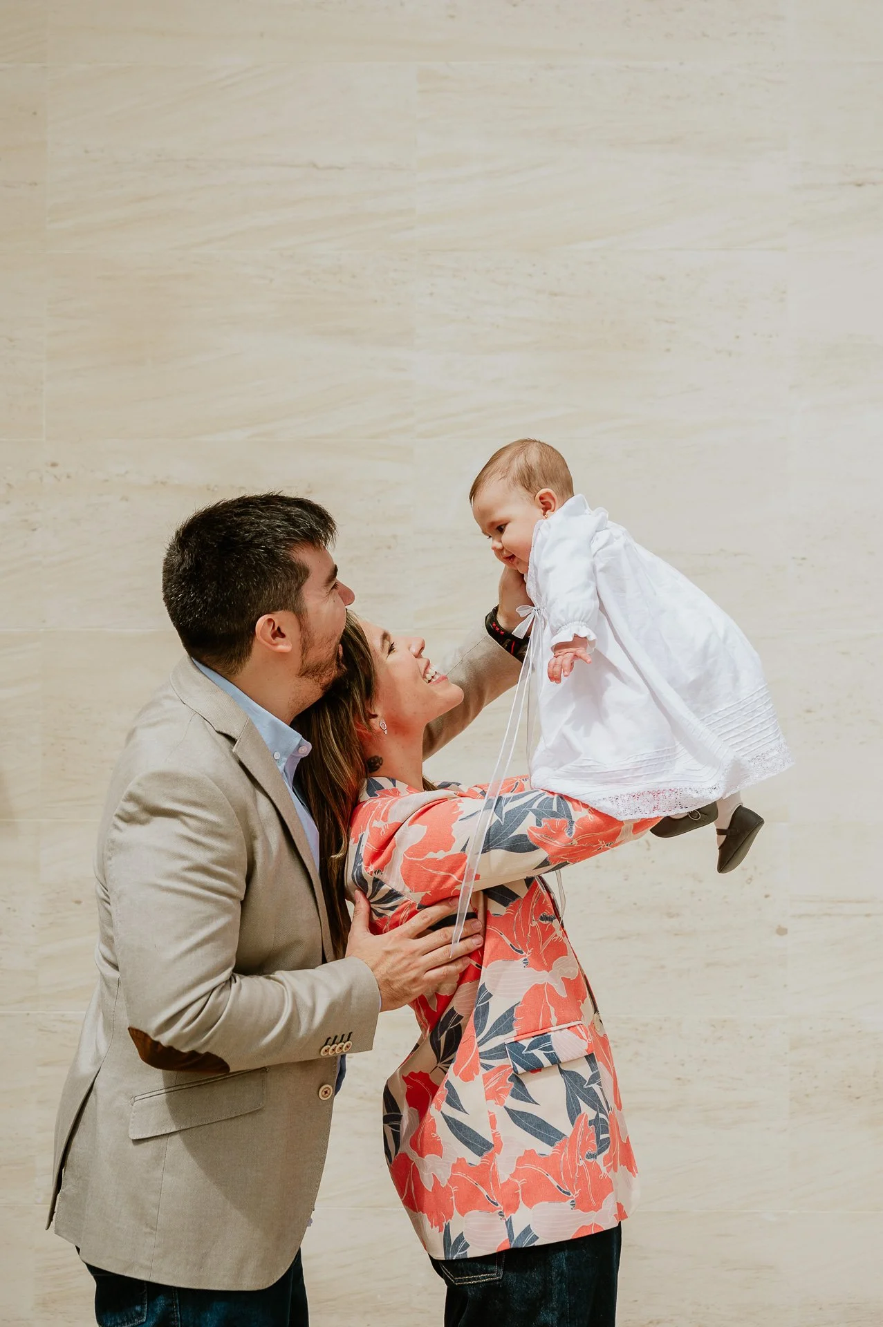 Una familia de tres personas, un hombre, una mujer y un niño pequeño, sonriendo y disfrutando un momento juntos.