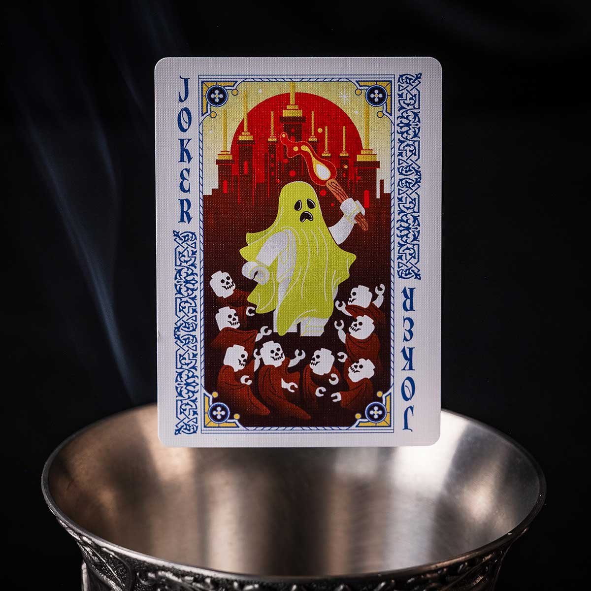 Floating joker poker card over a silver goblet with subtle smoke